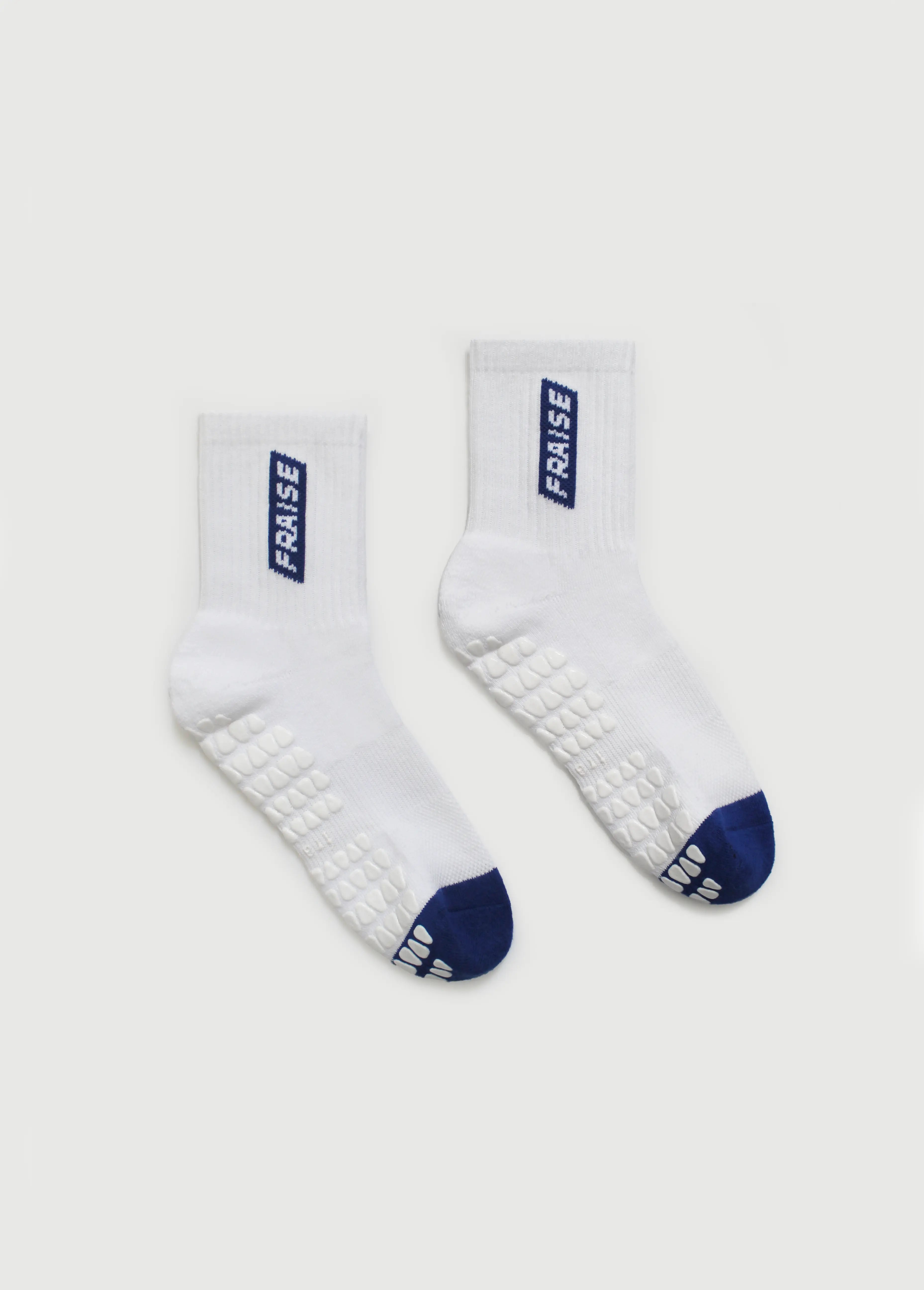 White pilates grip socks with blue accents and 'FRAISE' branding on a light gray background