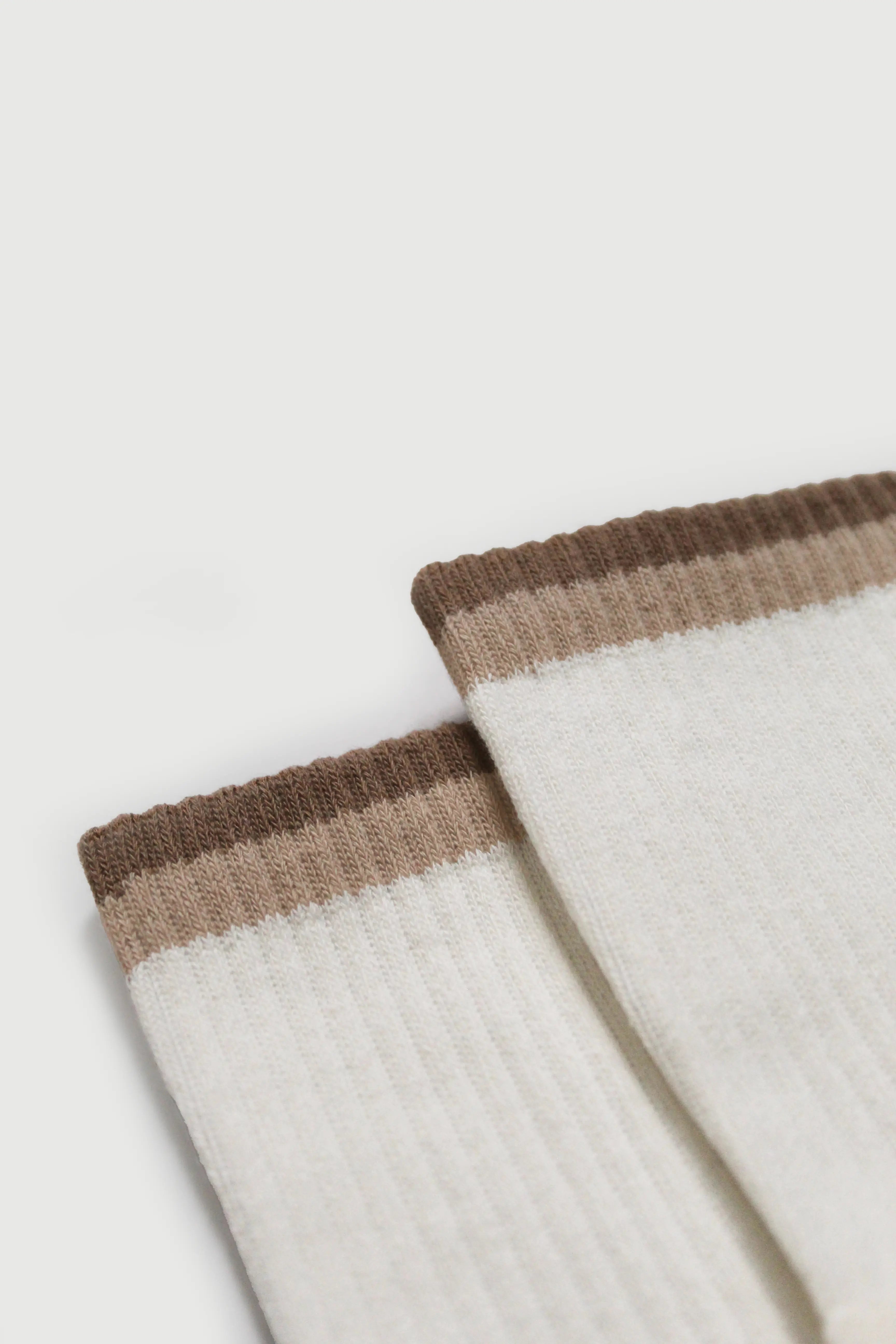Close-up of beige and brown striped pilates grip socks on a light background