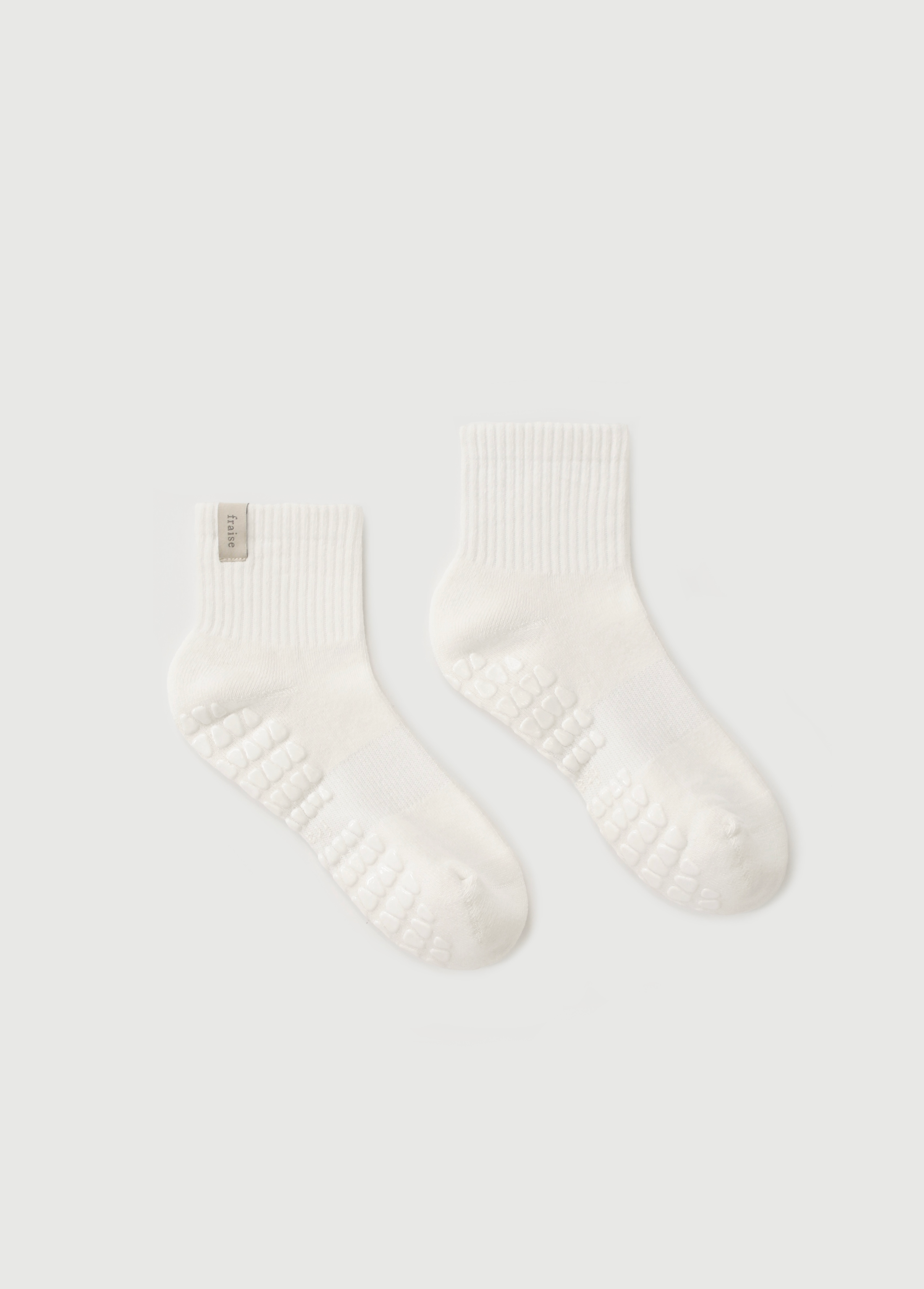 Pair of soft white quarter length socks on a light gray background