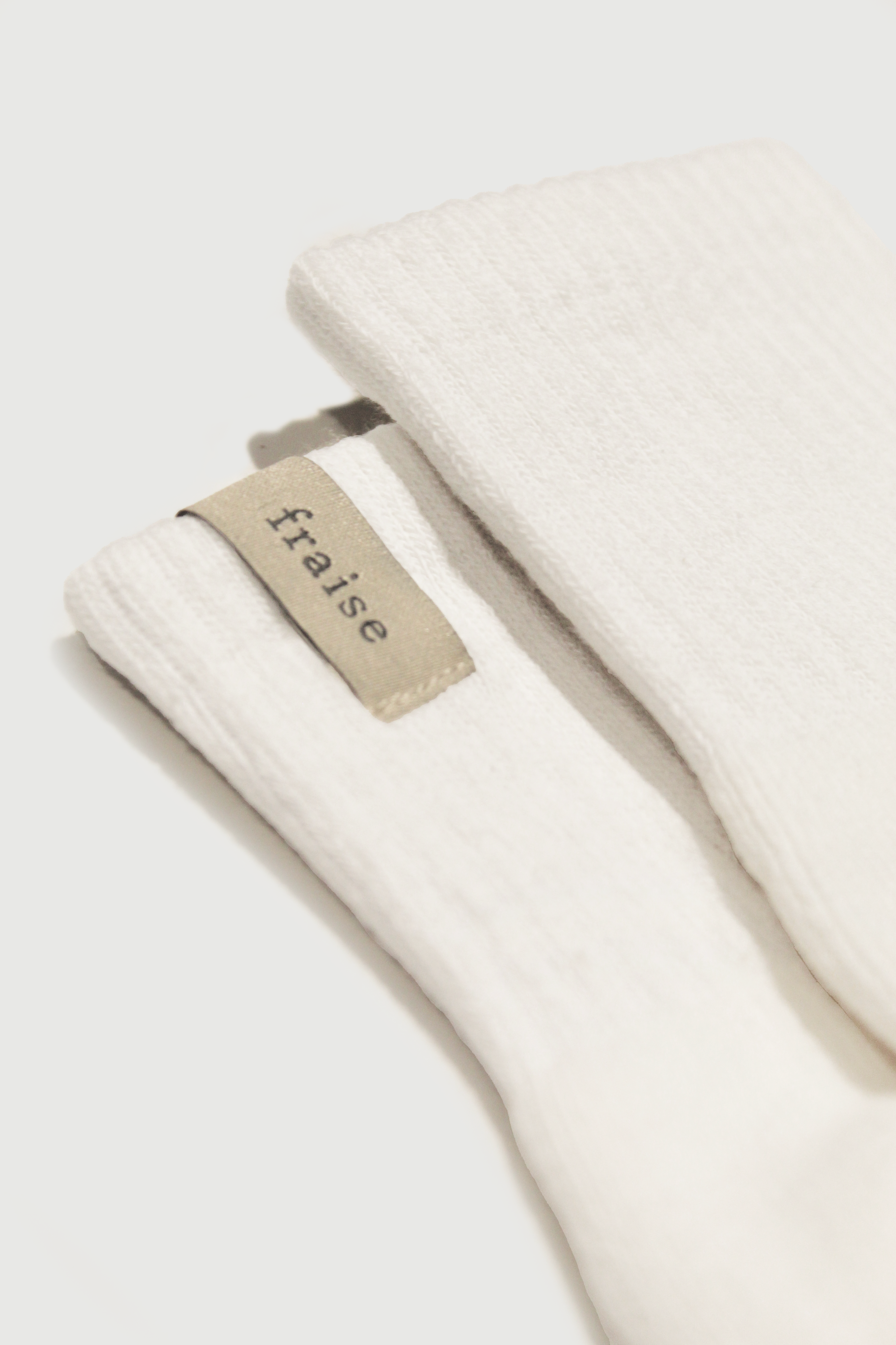Close up of soft white socks with 'fraise' label
