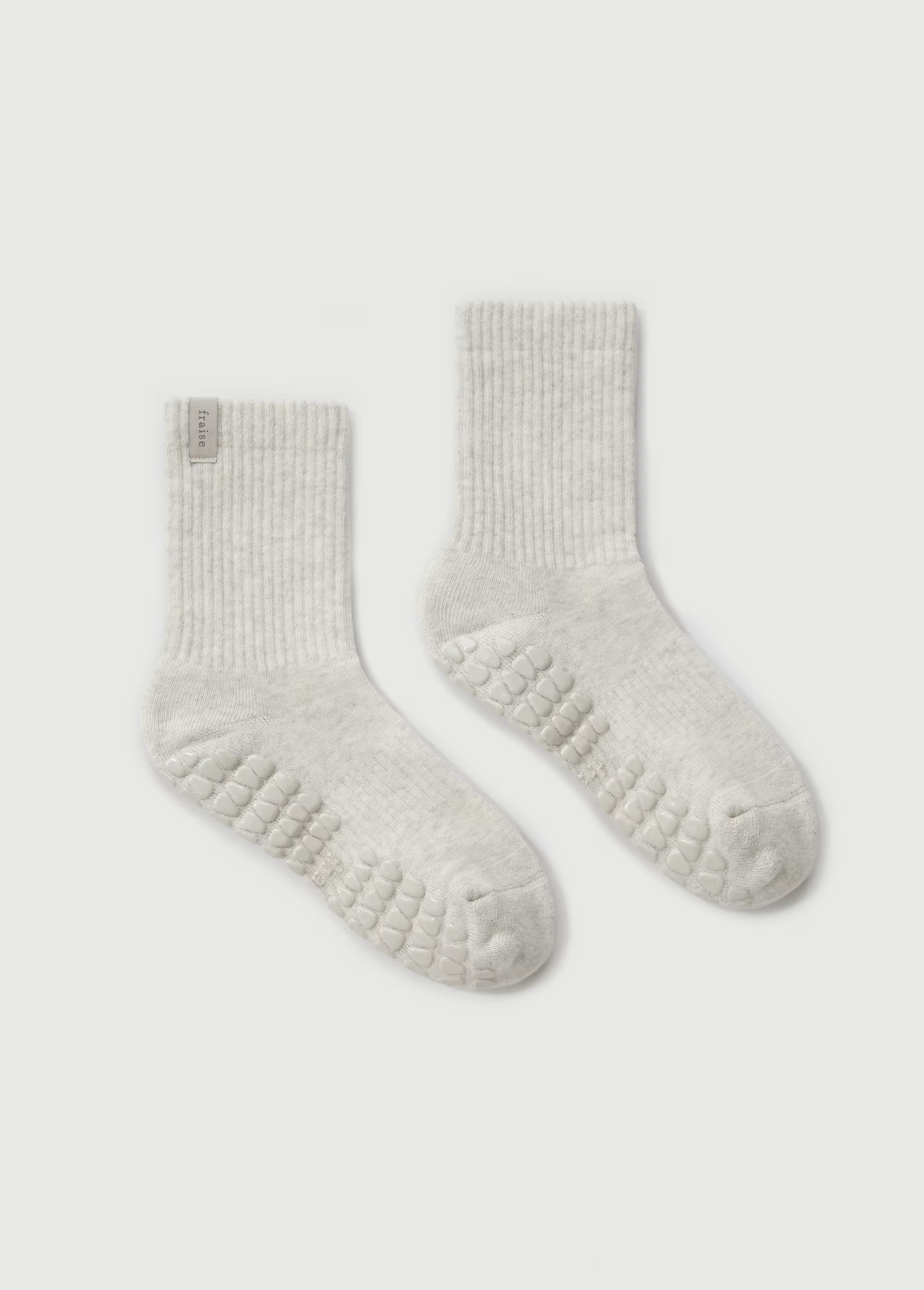 Pair of light gray pilates grip socks on a white background