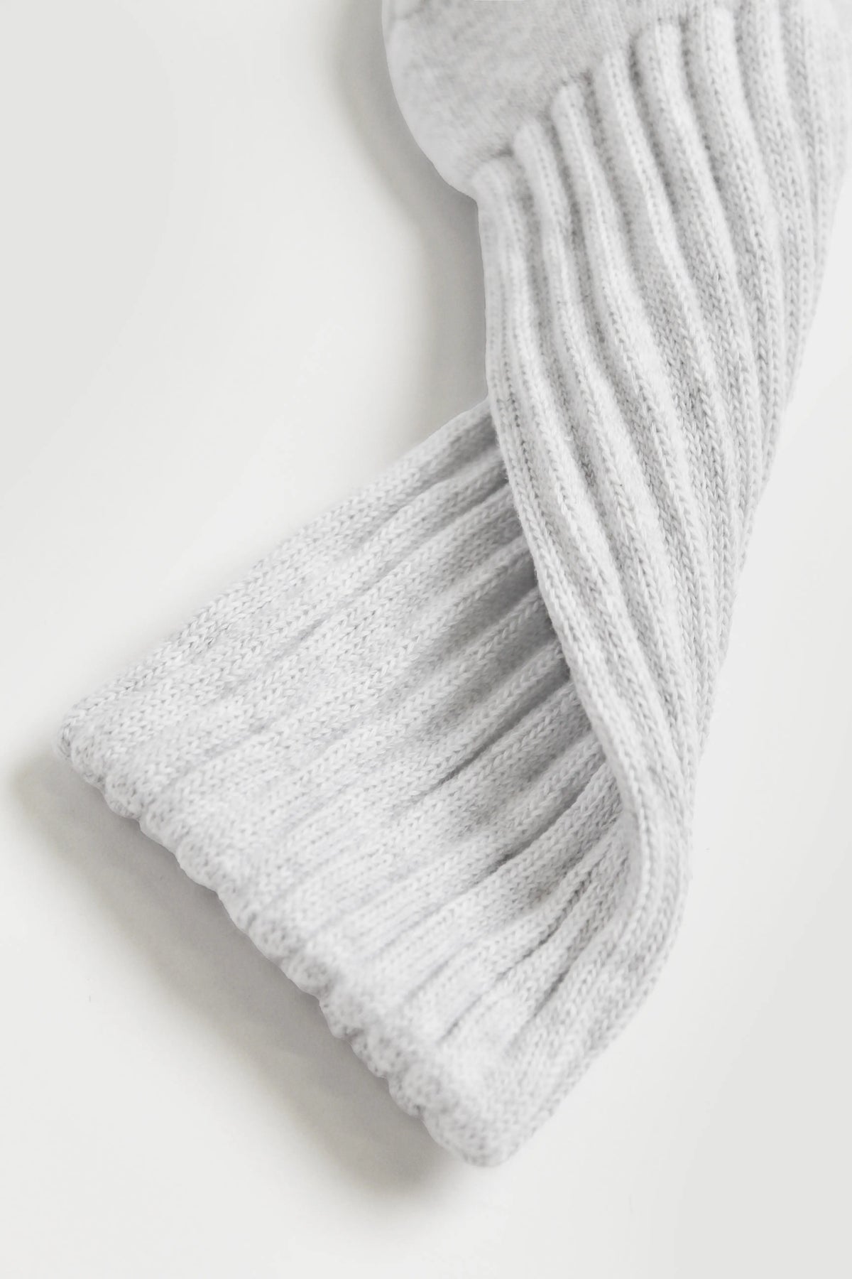 A close-up of a light gray pilates socks laid diagonally on a clean white background.