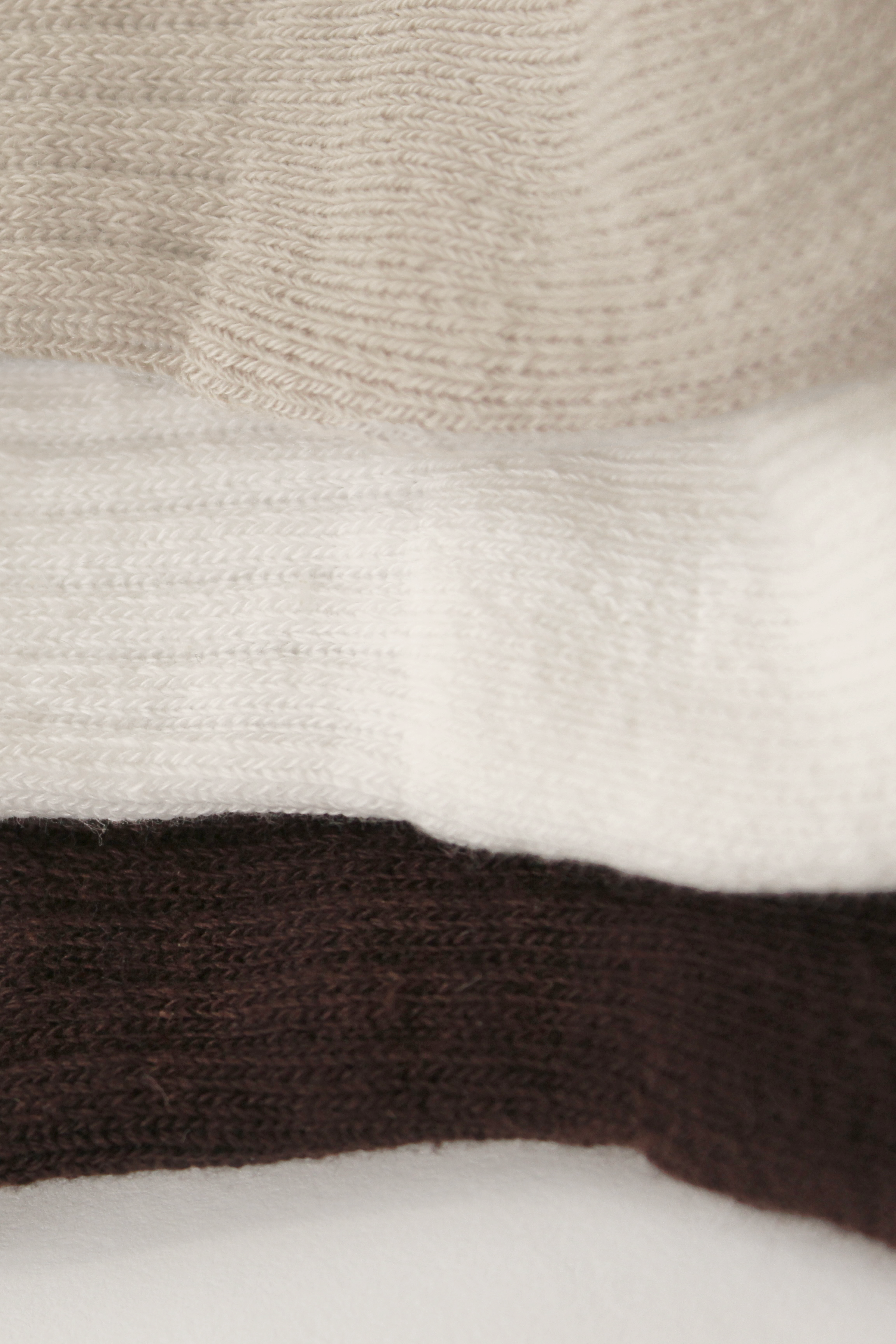 Close-up of Pilates grip socks with brown, white, and beige colors.